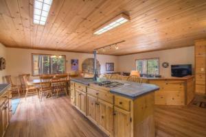 een grote keuken met houten vloeren en een eetkamer bij Whiskey Springs by AvantStay Classic Cabin Near Tahoe Donner Ski Area in Truckee