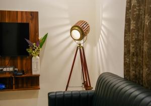 a lamp in a living room next to a couch at Hotel Urban Sleep Airport Zone in Shamshabad