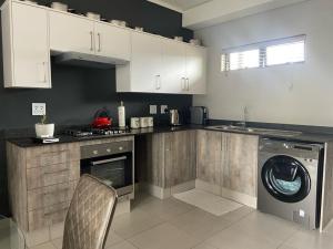 a kitchen with a washing machine and a dishwasher at Green Valley Bliss in Boschrand