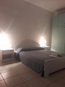 1 dormitorio con 1 cama y 2 mesitas de noche con lámparas en Summer aura - seaside place, en Istron