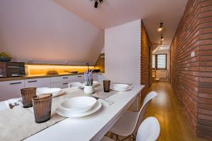 eine Küche mit einem weißen Tisch und weißen Stühlen in der Unterkunft Apartament u Wróbla in Leśnica