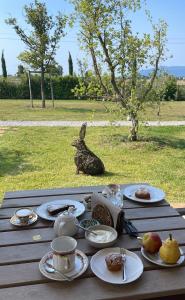 einen Tisch mit Teller mit Lebensmitteln mit Kaninchen in der Unterkunft Casale Oliveta in Orbetello