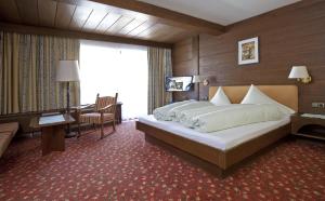 a hotel room with a large bed and a desk at Sporthotel St. Anton in Sankt Anton am Arlberg