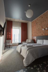 1 dormitorio con 2 camas y pared de ladrillo en Resume apartments, en Kaunas