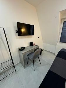 een kamer met een bureau en een televisie aan de muur bij Moparts in Oberhausen