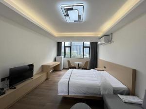 um quarto de hotel com uma cama e uma televisão em Weisu Service Apartment - Shenzhen Songpingshan Science and Technology Park Store em Shenzhen