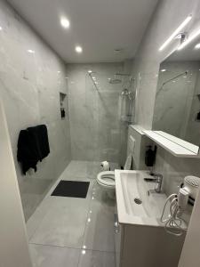 a white bathroom with a shower and a sink at Moparts in Oberhausen