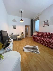 ein Wohnzimmer mit einem roten Sofa auf einem Holzboden in der Unterkunft Casa Estrella in Duisburg