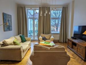 a living room with two couches and a tv at Apartament Bryza przy molo, parku i placu zabaw in Sopot