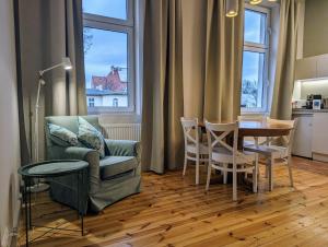 - un salon avec un canapé et une table avec des chaises dans l'établissement Apartament Bryza przy molo, parku i placu zabaw, à Sopot