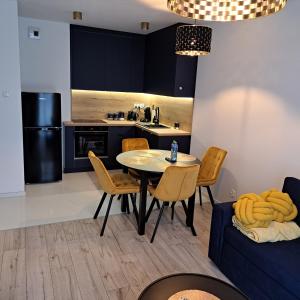 Apartament Grand في كوشالين: مطبخ وغرفة طعام مع طاولة وكراسي
