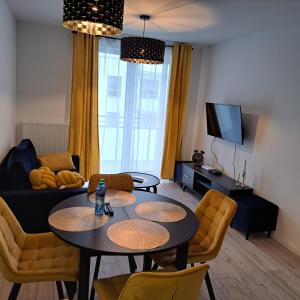 sala de estar con mesa y sofá en Apartament Grand en Koszalin