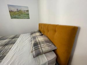 un letto con testiera gialla in una camera da letto di La Maison de Sara a Pont-Saint-Martin