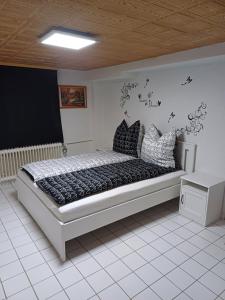 1 dormitorio con 1 cama grande con almohadas blancas y negras en Home Medau Spiga 