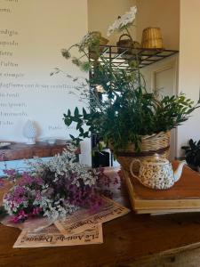 una mesa con flores y una cesta de plantas en Casale Oliveta en Orbetello