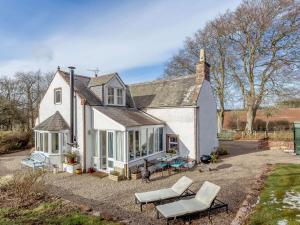 a white house with a table and chairs in front of it at 3 Bed in Turriff 75489 in Turriff