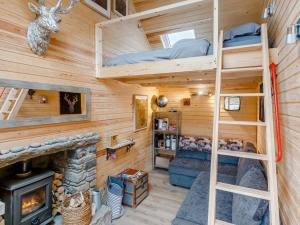 a room with bunk beds and a fireplace in a log cabin at 1 Bed in Pitlochry 75678 in Pitlochry