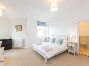 een witte slaapkamer met een wit bed en een raam bij 4 Bed in Coldingham CA256 in Coldingham