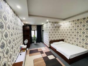 een slaapkamer met een bed en een bureau in een kamer bij Cô Chung Hotel in Lao Cai