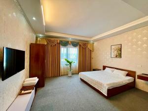 a hotel room with a bed and a television at Cô Chung Hotel in Lao Cai