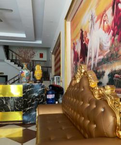 een gouden bank in een kamer met een schilderij bij Cô Chung Hotel in Lao Cai