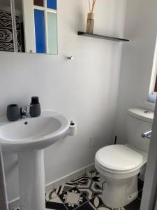 Milner Cottage: Digital Nomad Oasis في كيب تاون: حمام أبيض مع حوض ومرحاض