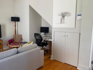 Milner Cottage: Digital Nomad Oasis في كيب تاون: غرفة معيشة مع أريكة ومكتب