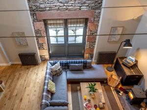 a living room with a couch and a stone wall at 3 Bed in Balfron Station CA374 in Kepculloch