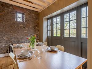 a dining room with a wooden table and chairs at 3 Bed in Balfron Station CA374 in Kepculloch