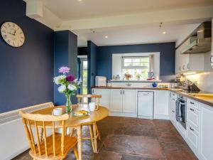 a kitchen with a table and a clock on the wall at 3 Bed in Brodick 77585 in Brodick