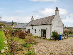 a white cottage with a black roof at 3 Bed in Brodick 77585 in Brodick