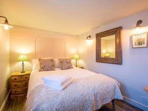 a bedroom with a bed with a mirror on the wall at 2 Bed in Stratford upon Avon 77617 in Wellesbourne Hastings