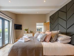 Un dormitorio con una cama grande con almohadas. en 5 Bed in Mundesley 77609 en Mundesley