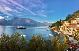 un bateau est amarré sur une rivière dans une ville dans l'établissement Divina Vita Apartments, à Varenna