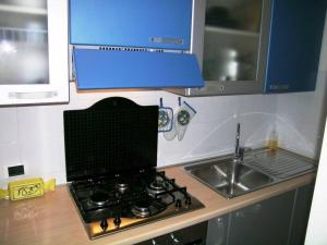 a kitchen counter with a stove and a sink at Appartamento Bilocale Cod. 18 - Taunus Vacanze in Marcelli