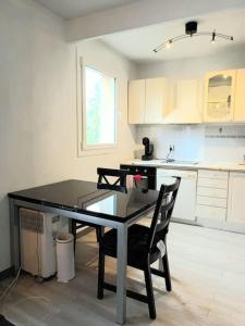 eine Küche mit einem Tisch und Stühlen im Zimmer in der Unterkunft Bel Appart calme proche CDG in Gonesse
