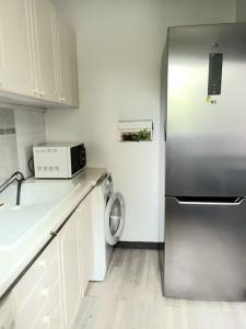 eine Küche mit einem Kühlschrank und einer Waschmaschine in der Unterkunft Bel Appart calme proche CDG in Gonesse