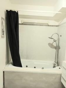 ein Badezimmer mit einer Badewanne mit einem schwarzen Duschvorhang in der Unterkunft Bel Appart calme proche CDG in Gonesse
