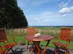 a table with a cup of coffee sitting between two chairs at 3 bed in Auldearn CA209 in Nairn
