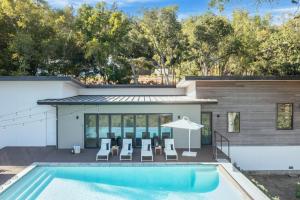 una piscina con sillas y una sombrilla junto a una casa en Chardonnay by AvantStay Modern Private Haven in Sonoma Infinity Pool w Valley Views, en Sonoma