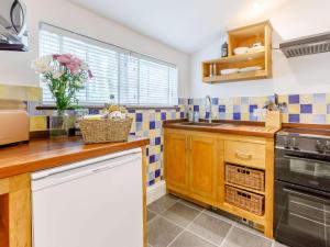 a kitchen with blue and white tiled walls at 1 Bed in Bude 75045 in Kilkhampton