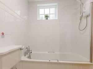 baño blanco con bañera y ventana en 1 Bed in Bude 75045, en Kilkhampton