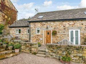 a stone house with a stone wall and a wooden door at 2 Bed in Harrogate 79165 in Weeton