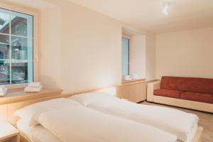 ein Schlafzimmer mit einem Bett und einem roten Sofa in der Unterkunft Lodge Brocco & Posta in San Bernardino