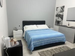 een slaapkamer met een bed met een blauwe en witte deken bij Camere Andrea in La Spezia