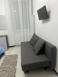 een bank in een woonkamer met een flatscreen-tv bij Camere Andrea in La Spezia
