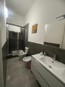 een badkamer met een wastafel, een toilet en een spiegel bij Camere Andrea in La Spezia