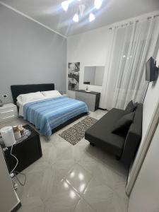 een slaapkamer met een bed en een bank erin bij Camere Andrea in La Spezia
