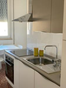 a kitchen with a sink with two cups on it at Appartamenti di Casa VerbaVolant in Siracusa