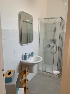 a bathroom with a sink and a glass shower at Appartamenti di Casa VerbaVolant in Siracusa